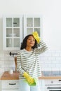 African-American female feeling relief after finishing cleaning kitchen. Tired of household duties Royalty Free Stock Photo