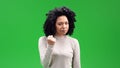 African American female on a green screen, angry and with her right hand raised and fisted. Royalty Free Stock Photo