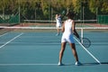 African american female player playing tennis game with young caucasian competitor at court