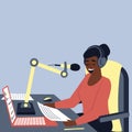 A African American female radio host is broadcasting in the studio