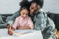 African american female soldier with daughter drawing
