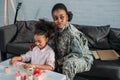 African american female soldier with daughter playing