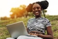 African american female student sitting in park working on laptop preparing for exams outdoors Royalty Free Stock Photo