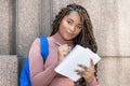 African american female university student with backpack writing notes Royalty Free Stock Photo