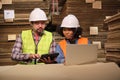 African American Female worker and colleague inspect paper storage warehouse