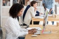 African American female worker using computer at shared workplac