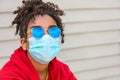 African American female young woman wearing sunglasses and face mask in COVID-19 pandemic Royalty Free Stock Photo