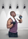 African american fit man drinking water against hanging light and copy space on grey background Royalty Free Stock Photo