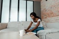 African american freelancer using laptop at coffee table with cup of tea and plate with toasts