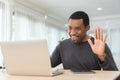 African American Freelancer waving hand while having video call with friends or family on laptop at home office. Black Male making Royalty Free Stock Photo