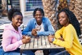 African american friends having breakfast sitting on table at coffee shop terrace Royalty Free Stock Photo