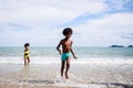 African American friendship in swimwear enjoying running to play the waves on beach. Ethnically diverse concept. Having fun after Royalty Free Stock Photo