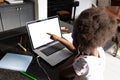 African american girl with afro hair pointing at laptop while studying over laptop at home Royalty Free Stock Photo