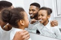 African-american girl brushing teeth together with dad