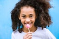 African american girl with curly hair outdoors eating lollipop. Royalty Free Stock Photo