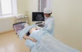 an African-American girl doctor conducts an ultrasound of a patient lying on the operating table. Royalty Free Stock Photo