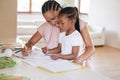 African american girl doing homework with her mom. A beautiful black woman helping her daughter with school work at home Royalty Free Stock Photo