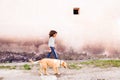 African american girl with her dog against concrete wall. Royalty Free Stock Photo