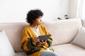 African american girl holding digital tablet touch screen typing scroll page at home. Woman with mobile tech device Royalty Free Stock Photo