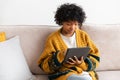 African american girl holding digital tablet touch screen typing scroll page at home. Woman with mobile tech device Royalty Free Stock Photo