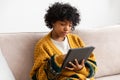 African american girl holding digital tablet touch screen typing scroll page at home. Woman with mobile tech device Royalty Free Stock Photo