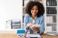 African American girl holds pen to read agreement document to sign land loan with real estate agent or bank teller, Royalty Free Stock Photo