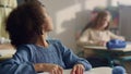 Girl raising hand at lesson. Female teacher helping student with class work Royalty Free Stock Photo