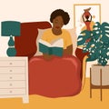 African American Girl Reading A Book. Feminine Daily Life And Everyday Routine Scene By Young Woman In Home Interior