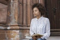 African American girl sitting on the street and looking straight. On her feet are the books Royalty Free Stock Photo