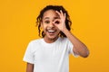 African American girl smiling, looking at the camera through fingers Royalty Free Stock Photo