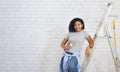 African american girl on stepladder holding a paint brush