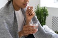 African American girl taking pill and holding glass of water Royalty Free Stock Photo