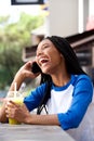 African american girl talking on mobile phone and laughing at cafe Royalty Free Stock Photo