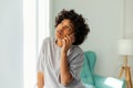 African american girl talking on smartphone at home indoor. Young woman with cell phone chatting with friends. Smiling Royalty Free Stock Photo