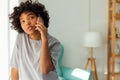 African american girl talking on smartphone at home indoor. Young woman with cell phone chatting with friends. Smiling Royalty Free Stock Photo