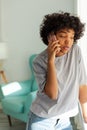 African american girl talking on smartphone at home indoor. Young woman with cell phone chatting with friends. Smiling Royalty Free Stock Photo