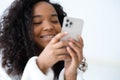 African American Girl using iPhone 12 smartphone pressing finger, reading social media internet, typing text or shopping