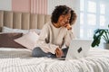 African American girl using laptop in bed at home office typing chatting reading writing email. Young black woman having Royalty Free Stock Photo