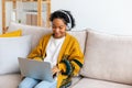 African american girl using laptop at home office looking at screen typing chatting reading writing email. Young woman Royalty Free Stock Photo