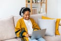 African american girl using laptop at home office looking at screen typing chatting reading writing email. Young woman Royalty Free Stock Photo