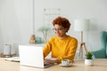 African american girl using laptop at home office looking at screen typing chatting reading writing email. Young woman Royalty Free Stock Photo