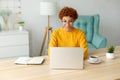 African american girl using laptop at home office looking at screen typing chatting reading writing email. Young woman Royalty Free Stock Photo