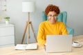 African american girl using laptop at home office looking at screen typing chatting reading writing email. Young woman Royalty Free Stock Photo