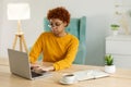 African american girl using laptop at home office looking at screen typing chatting reading writing email. Young woman