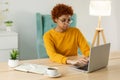 African american girl using laptop at home office looking at screen typing chatting reading writing email. Young woman