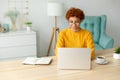 African american girl using laptop at home office looking at screen typing chatting reading writing email. Young woman