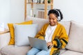 African american girl using laptop at home office looking at screen typing chatting reading writing email. Young woman