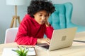 African american girl using laptop at home office looking at screen typing chatting reading writing email. Young woman Royalty Free Stock Photo