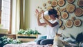 African American girl is using virtual reality glasses sitting on bed at home, she is moving hands and head and smiling Royalty Free Stock Photo