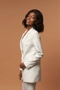 Girl in white suit posing on beige background Royalty Free Stock Photo